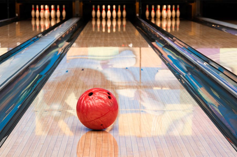Bowling lane with a red bowling ball rolling towards the pins at a Paphos bowling alley in Cyprus.