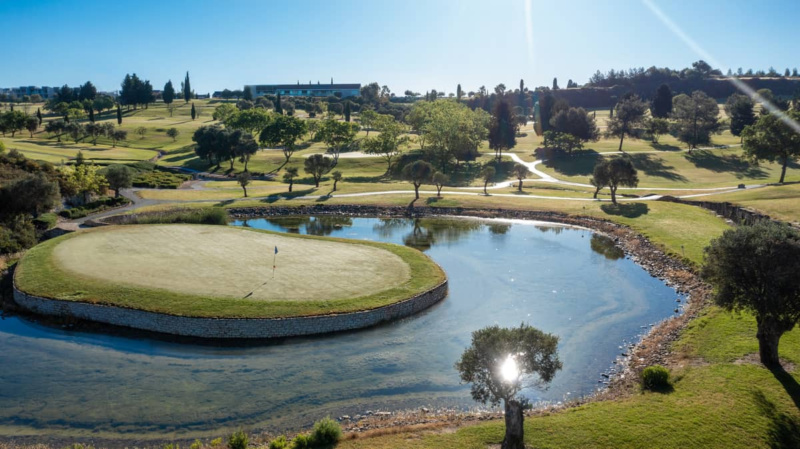 Green fairways and a landscaped pond at Minthis Hills Golf Club set among rolling hills near Paphos, Cyprus.