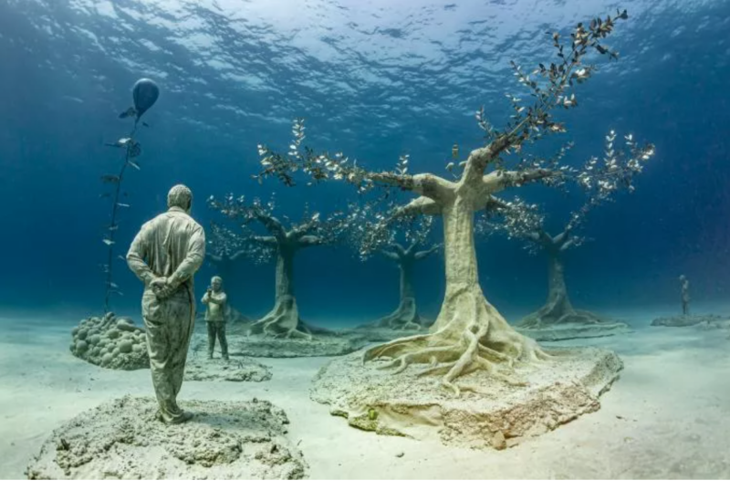 Underwater sculptures of human figures and a tree at the MUSAN underwater museum in the sea off Ayia Napa, Cyprus.
