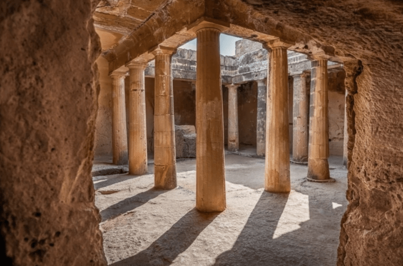 Ancient underground stone tomb with columns and arched passageways at the Tombs of the Kings archaeological site in Paphos, Cyprus.