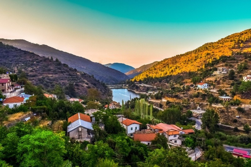 Scenic view of Kalopanayiotis village with houses spread across a lush green valley in the Troodos Mountains of Cyprus.