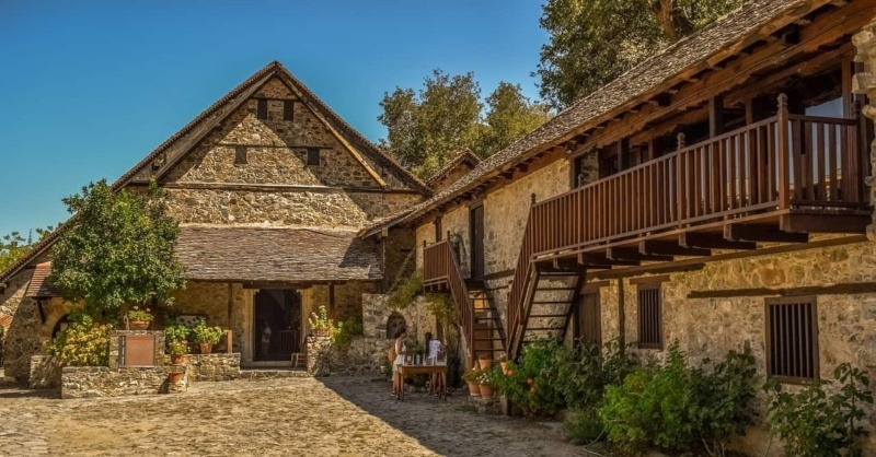 Stone monastery complex of Agios Ioannis Lampadistis with steep timber-protected roofs, set in the green Troodos Mountains of Cyprus.