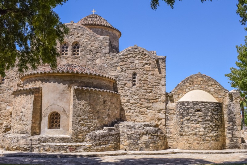 The stone-built Byzantine church of Panagia Angeloktisti with a rounded apse, standing under a blue sky in the village of Kiti, Cyprus.
